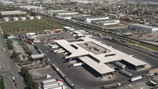 4K aerial stock footage tilt from big rigs to reveal and orbit Otay Mesa Port of Entry on the US/Mexico Border, Otay Mesa, California Aerial Stock Footage | DCA08_087E