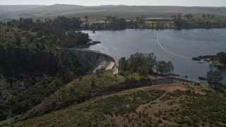 4K aerial stock footage orbit, approach, fly over the dam on Lower Otay Lake, California Aerial Stock Footage | DCA08_109E