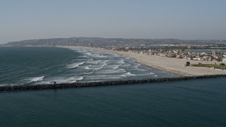 DCA08_229E - 4K aerial stock footage fly over ocean waves to approach a beach and beachfront homes, Mission Beach, California