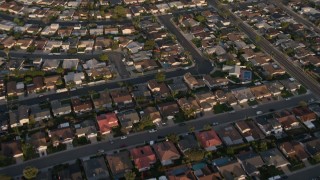 4K aerial stock footage of a reverse view of tract homes in the suburbs, Clairemont Mesa East, California, Sunset Aerial Stock Footage | DCA08_271