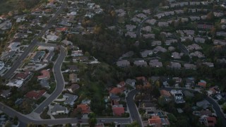 4K aerial stock footage of a reverse view of tract homes and reveal park, La Jolla, California, Sunset Aerial Stock Footage | DCA08_282