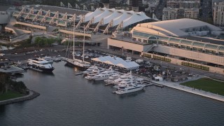 4K aerial stock footage of yachts docked by convention center, Downtown San Diego, California, Sunset Aerial Stock Footage | DCA08_296