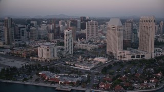 DCA08_320E - 4K aerial stock footage pan across hotel to reveal seafood company in Downtown San Diego, California, Sunset