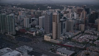 4K aerial stock footage of panning past city skyscrapers and streets in Downtown San Diego, California, Sunset Aerial Stock Footage | DCA08_322