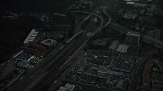 DCA08_333 - 4K aerial stock footage fly away from freeway interchange, reveal a strip mall, Mission Valley, California, twilight