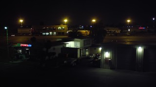 DCA08_378 - 4K aerial stock footage of flying by hangars to land at Montgomery Field airport, California, Night