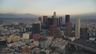 5K aerial stock footage tilt from office buildings to reveal and approach Downtown Los Angeles at sunset, California Aerial Stock Footage | DCLA_024