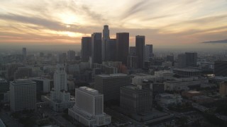 5K aerial stock footage approach Downtown Los Angeles skyline with setting sun behind clouds, California Aerial Stock Footage | DCLA_035