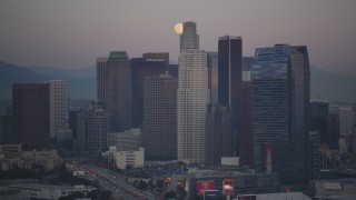 5K aerial stock footage of a full moon behind Downtown Los Angeles skyscrapers at twilight, California Aerial Stock Footage | DCLA_065