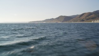 DCLA_157 - 5K aerial stock footage fly low over the ocean toward the coast of Malibu, California