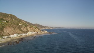 5K aerial stock footage tilt from ocean to reveal and approach beachfront homes on Malibu coast, California Aerial Stock Footage | DCLA_177