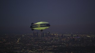 5K aerial stock footage of flying by an advertising blimp and reveal Downtown Los Angeles skyline at twilight, California Aerial Stock Footage | DCLA_279