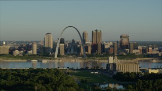 5.7K aerial stock footage reverse shot of the Arch and skyline seen from a park across the Mississippi River, sunrise, Downtown St. Louis, Missouri Aerial Stock Footage | DX0001_000520