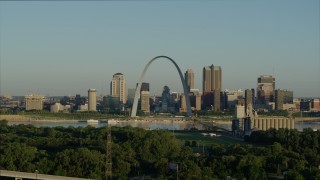 DX0001_000523 - 5.7K aerial stock footage ascending over park toward Mississippi River, Arch and skyline at sunrise, Downtown St. Louis, Missouri