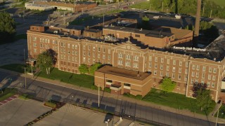 DX0001_000684 - 5.7K aerial stock footage orbit and fly away from abandoned hospital at sunset in East St. Louis, Illinois