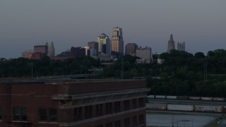 5.7K aerial stock footage of the city skyline at twilight while descending to reveal brick building, Downtown Kansas City, Missouri Aerial Stock Footage | DX0001_001194