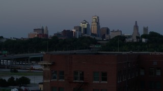 5.7K aerial stock footage descend with view of skyline at twilight, reveal brick building, Downtown Kansas City, Missouri Aerial Stock Footage | DX0001_001203