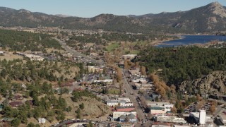 DX0001_001998 - 5.7K aerial stock footage flyby shops lining road through Estes Park, Colorado lake and mountains in distance