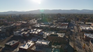 DX0001_002025 - 5.7K aerial stock footage flying away from shops with view of taller office buildings in Fort Collins, Colorado