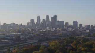 5.7K aerial stock footage ascend from behind trees to reveal skyline at sunrise in Downtown Minneapolis, Minnesota Aerial Stock Footage | DX0001_002090