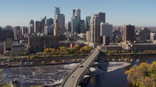 DX0001_002142 - 5.7K aerial stock footage descend near a bridge spanning the river with a view of the skyline, Downtown Minneapolis, Minnesota