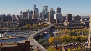 5.7K aerial stock footage descend near a bridge spanning the river with view of the skyline, Downtown Minneapolis, Minnesota Aerial Stock Footage | DX0001_002148