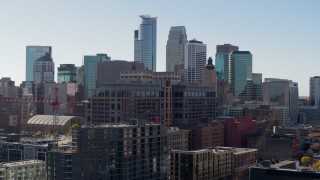 5.7K aerial stock footage descend by office building and construction, city's skyline in background, Downtown Minneapolis, Minnesota Aerial Stock Footage | DX0001_002164