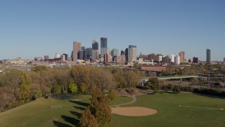 5.7K aerial stock footage a reverse view of the city skyline while descending toward a park, Downtown Minneapolis, Minnesota Aerial Stock Footage | DX0001_002173