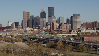 5.7K aerial stock footage descend toward trees with a view of the city skyline, Downtown Minneapolis, Minnesota Aerial Stock Footage | DX0001_002175