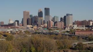 5.7K aerial stock footage ascend from trees to a stationary view of the city skyline, Downtown Minneapolis, Minnesota Aerial Stock Footage | DX0001_002180