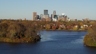 5.7K aerial stock footage of the city's skyline seen while passing by lakeside houses, Downtown Minneapolis, Minnesota Aerial Stock Footage | DX0001_002193