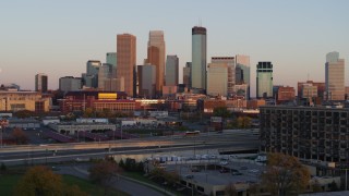 5.7K aerial stock footage ascend from park to focus on the city's skyline at sunset, Downtown Minneapolis, Minnesota Aerial Stock Footage | DX0001_002233