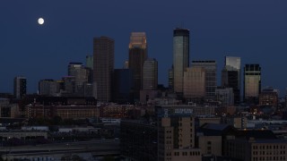 5.7K aerial stock footage flyby the moon above skyscrapers in city skyline at twilight, Downtown Minneapolis, Minnesota Aerial Stock Footage | DX0001_002274