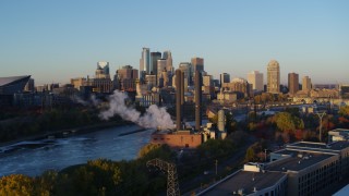 5.7K aerial stock footage ascend to reveal power plant, and the city skyline across the river at sunrise, Downtown Minneapolis, Minnesota Aerial Stock Footage | DX0001_002289