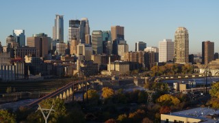 5.7K aerial stock footage pass the city skyline across the river at sunrise, reveal smoke stacks, Downtown Minneapolis, Minnesota Aerial Stock Footage | DX0001_002310