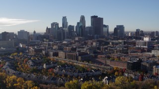 5.7K aerial stock footage descend toward trees and focus on skyline of Downtown Minneapolis, Minnesota Aerial Stock Footage | DX0001_002340