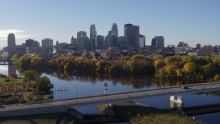 5.7K aerial stock footage of the city skyline, seen while ascending from the river and a bridge, Downtown Minneapolis, Minnesota Aerial Stock Footage | DX0001_002346