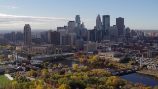 DX0001_002355 - 5.7K aerial stock footage flying by bridges spanning the river and the city skyline, Downtown Minneapolis, Minnesota