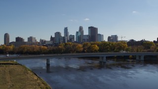 5.7K aerial stock footage reverse view of bridge over river with view of city skyline, Downtown Minneapolis, Minnesota Aerial Stock Footage | DX0001_002450