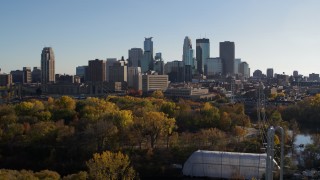 5.7K aerial stock footage descend by trees and focus on the city skyline, Downtown Minneapolis, Minnesota Aerial Stock Footage | DX0001_002485