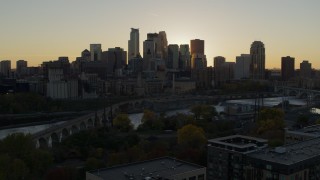 5.7K aerial stock footage view of city skyline during descent by bridge and river at sunset, Downtown Minneapolis, Minnesota Aerial Stock Footage | DX0001_002528