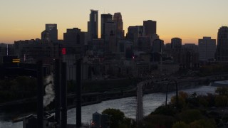 5.7K aerial stock footage of the city's skyline and river bridge at sunset, seen from power plant, Downtown Minneapolis, Minnesota Aerial Stock Footage | DX0001_002558