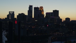 5.7K aerial stock footage flyby the skyscrapers in the city skyline at twilight, reveal smoke stacks, Downtown Minneapolis, Minnesota Aerial Stock Footage | DX0001_002571