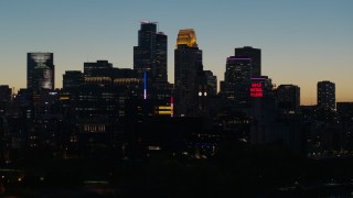 DX0001_002586 - 5.7K aerial stock footage focus on the city skyline lit for the night at twilight, Downtown Minneapolis, Minnesota