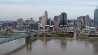 5.7K aerial stock footage flying by the city skyline and bridge spanning Ohio River, Downtown Cincinnati, Ohio Aerial Stock Footage | DX0001_002600