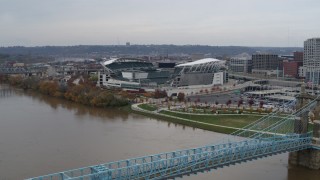 DX0001_002611 - 5.7K aerial stock footage fly over bridge spanning river to approach football stadium, Downtown Cincinnati, Ohio