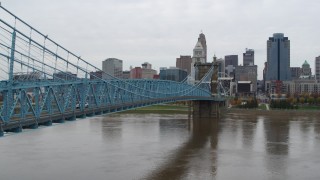 DX0001_002633 - 5.7K aerial stock footage ascend from river beside the bridge with the city skyline in background, Downtown Cincinnati, Ohio