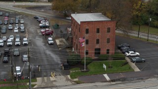 DX0001_002715 - 5.7K aerial stock footage ascend while approaching a brick police station in Columbus, Ohio