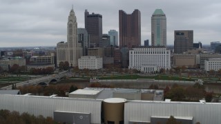 DX0001_002721 - 5.7K aerial stock footage of passing by Discovery Bridge and Scioto River by city skyline, Downtown Columbus, Ohio