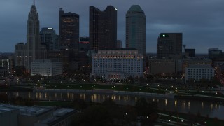 5.7K aerial stock footage of the city skyline by the Scioto River at sunset, Downtown Columbus, Ohio Aerial Stock Footage | DX0001_002758